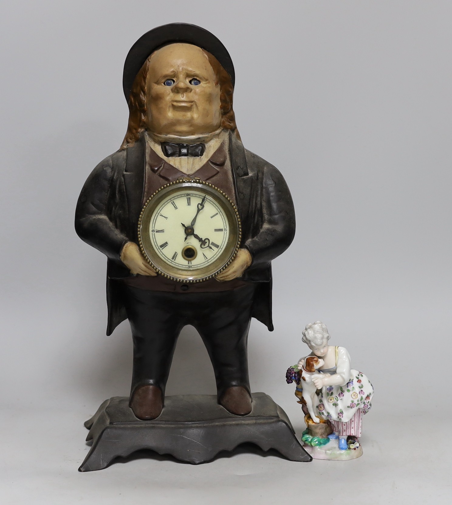 An American cast iron novelty 'John Bull' timepiece and a porcelain group